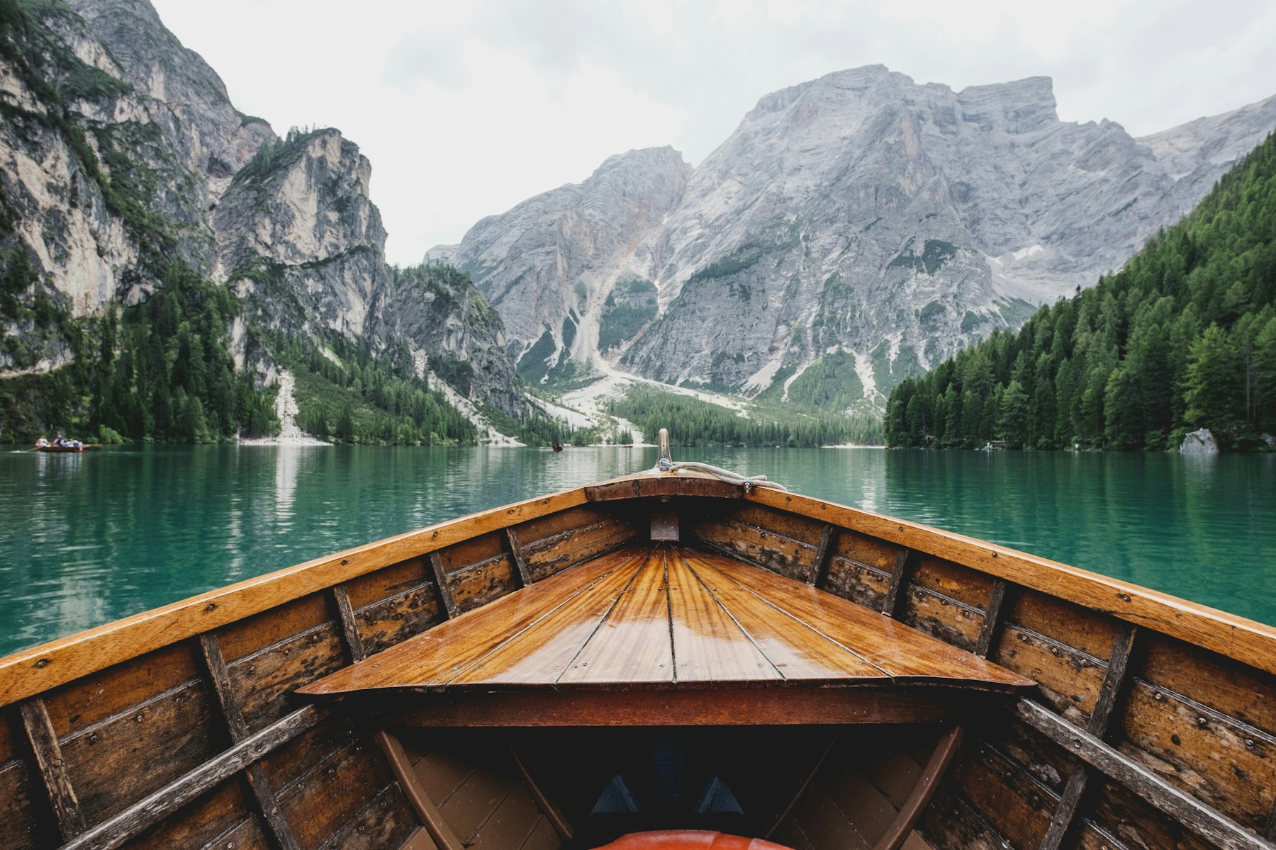 Wooden boat on an alpine lake surrounded by mountains